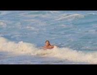 Girl pink surfboard blue bikini running out of water from wave gets knocked over