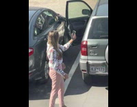 Woman in a floral top selfies at the parking lot