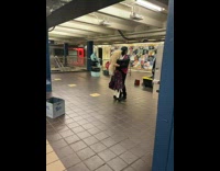 Guy salsa dancing with skeleton in subway performance