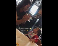 Guy spraying water into babies mouth and slowly gets further away