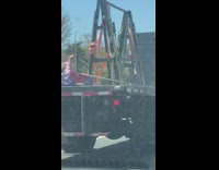 Tricycle secured to back of flatbed trailer on big rig truck