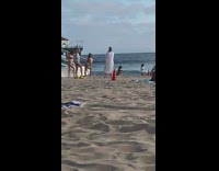 Three girls beside surfboard and lifeguard post  beach