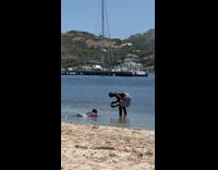 Collab IITW - Woman in a colorful swimsuit lie down at the beach shore - dock behind