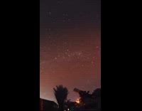 Man filming aurora borealis from telescope 