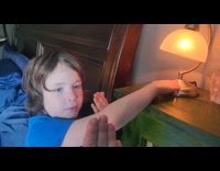 Kid holds lamp taps nose adjust light