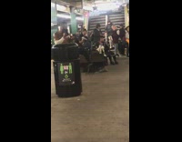 Shirtless sweaty guy practices fighting moves and kicks in the air in subway station