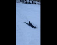 Girl jumps and slides down hill snow 