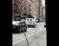 White van dragging trash bag as it drives away