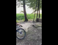 Black shirt guy jumps bicycle over logs