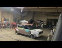 Garage guy in small brown rusty car 