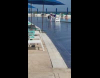 White dress girl waves scarves around pool 