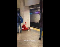 Guy in santa costume having chicfila at subway station floor