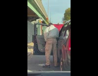 Guy pees standing out of front seat of car