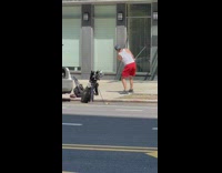 Man in red shorts practicing golf on street