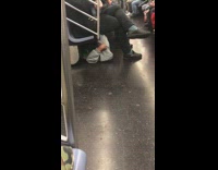 Man black hat sleeps under seats on crowded subway train