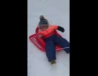 Baby in sled looks unimpressed by snow 