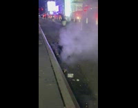 Guy lays back on street near steam