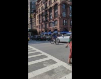 Guy balances ball on head while bike riding