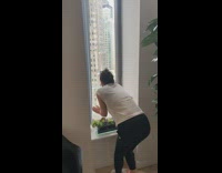 woman struggles to get bird of our her apartment through window