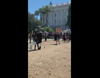 Woman poses for a professional photoshoot with a sign at a protest 