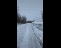 White car in snow broken back bumper