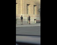 Woman in black coat walks and models on the sidewalk