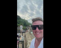 Man selfie video laugh at woman sitting on ledge