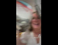 Woman in pink pants in home goods messing around being silly