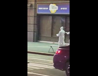 People walk down sidewalk wearing all white 