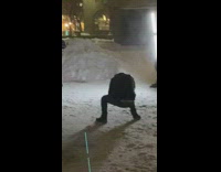 Woman in black suit in a windy and snowy photoshoot