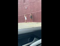 Black shirt girl red building parking lot 