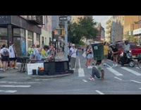 Man balance trash can on head near street DJ