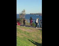 Little girl red tracksuit mom ocean railing