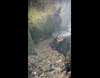 Girl black shirt touch large boulder beach