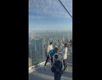 Two men stands in front of rooftop glass window