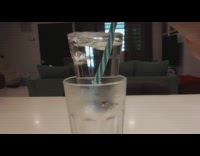 Guy lifts straw ice water glass cup