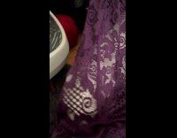 Woman help white cat stuck in purple dress