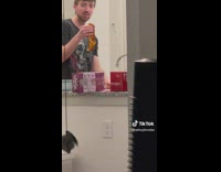 Guy holding enchilada in the kitchen