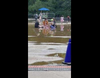 Group of people sit on ground stagnant water