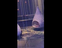 Girl sits in white nest swing flash 