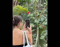 Woman take multiple shots friend near hut