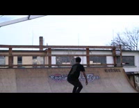 Skater jumps and stands on ramp rail on skateboard