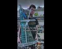 Guy in black Star Wars shirt moving lego tower