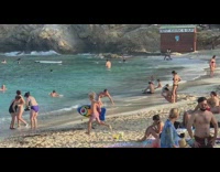 White shorts guy crawls lays back beach 