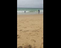 Man blue long sleeve top splashes water beach