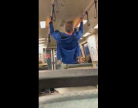 Drunk man with Golden State Warriors shirt holds onto subway handrails and does backflip 