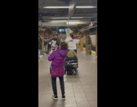 Woman dancing with dog along to classical music performance in subway