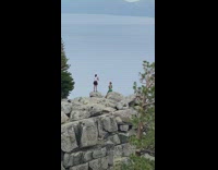 Woman in green outfit sits on the mountain rock