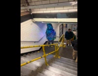 Collab WINY - Man in Christmas tree costume walking on subway stairs