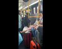 Woman rests bare foot out on her luggage suitcase on subway train